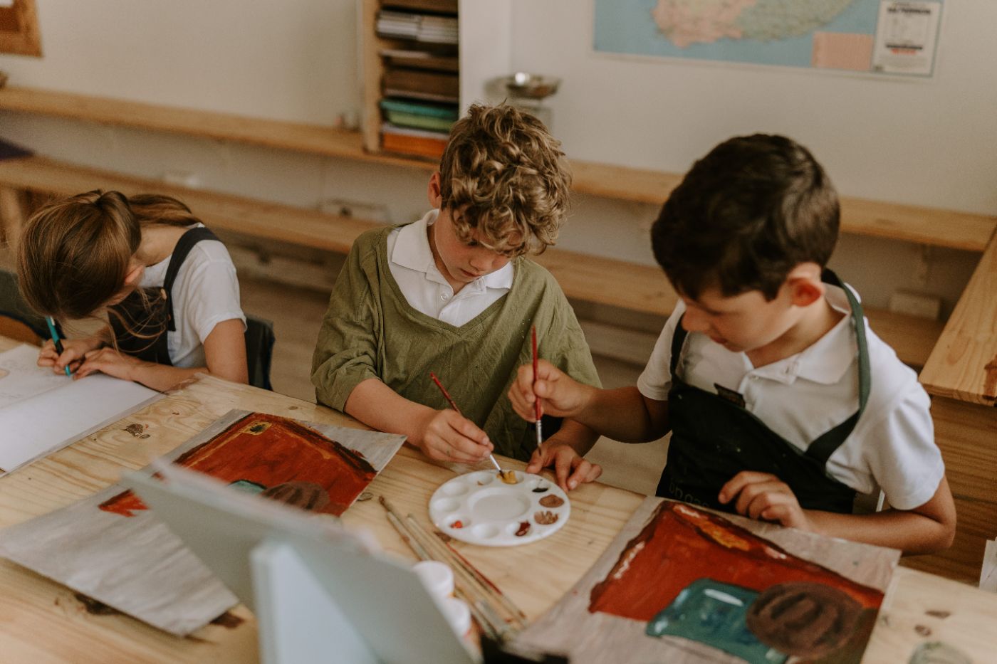 Two boys painting together in class