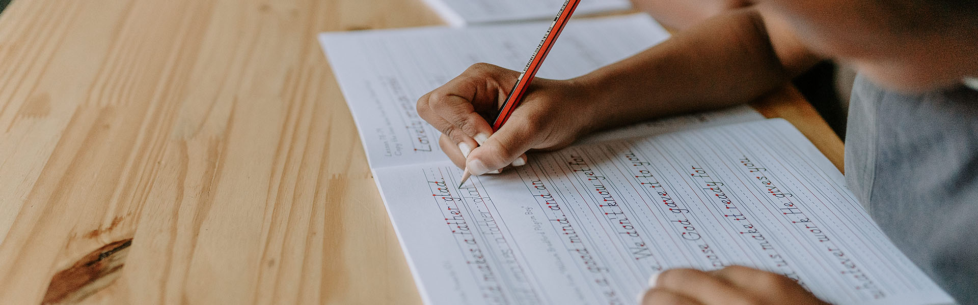 A child practising handwriting at Three Peaks School